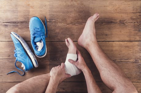 man-with-foot-with-bandage-holding-his-ankle